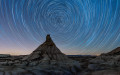 Long exposure taken in the natural area of Bardenas Reales of Navarre, Spain. This is a semnidesertic clay region eroded by rain and winds. The  natural monument in the image center is named Castildetierra. All stars seem to rotate around the Polar star which is always located at North in the Northern hemisphere.